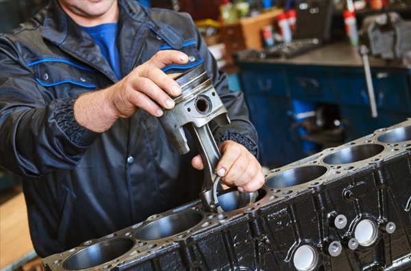 a man doing mechanical repair on an engine in a garage